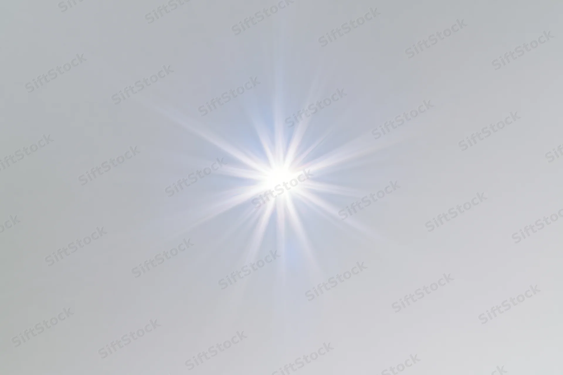 Bright lens flare starburst centered on plain white background