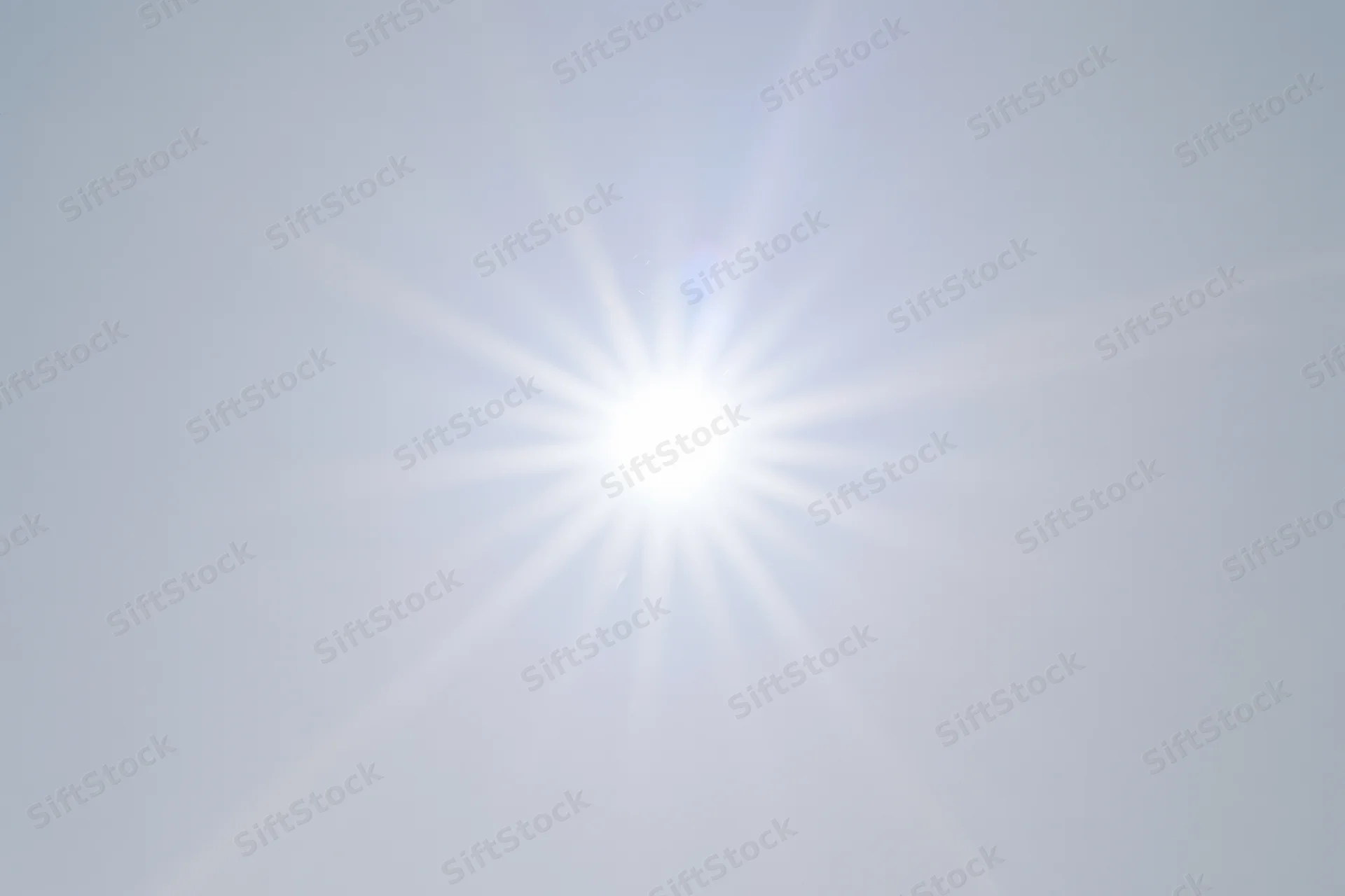 Bright lens flare starburst against plain white background