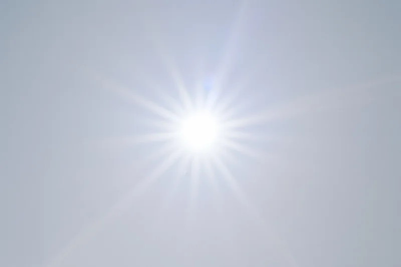 Bright lens flare starburst against plain white background