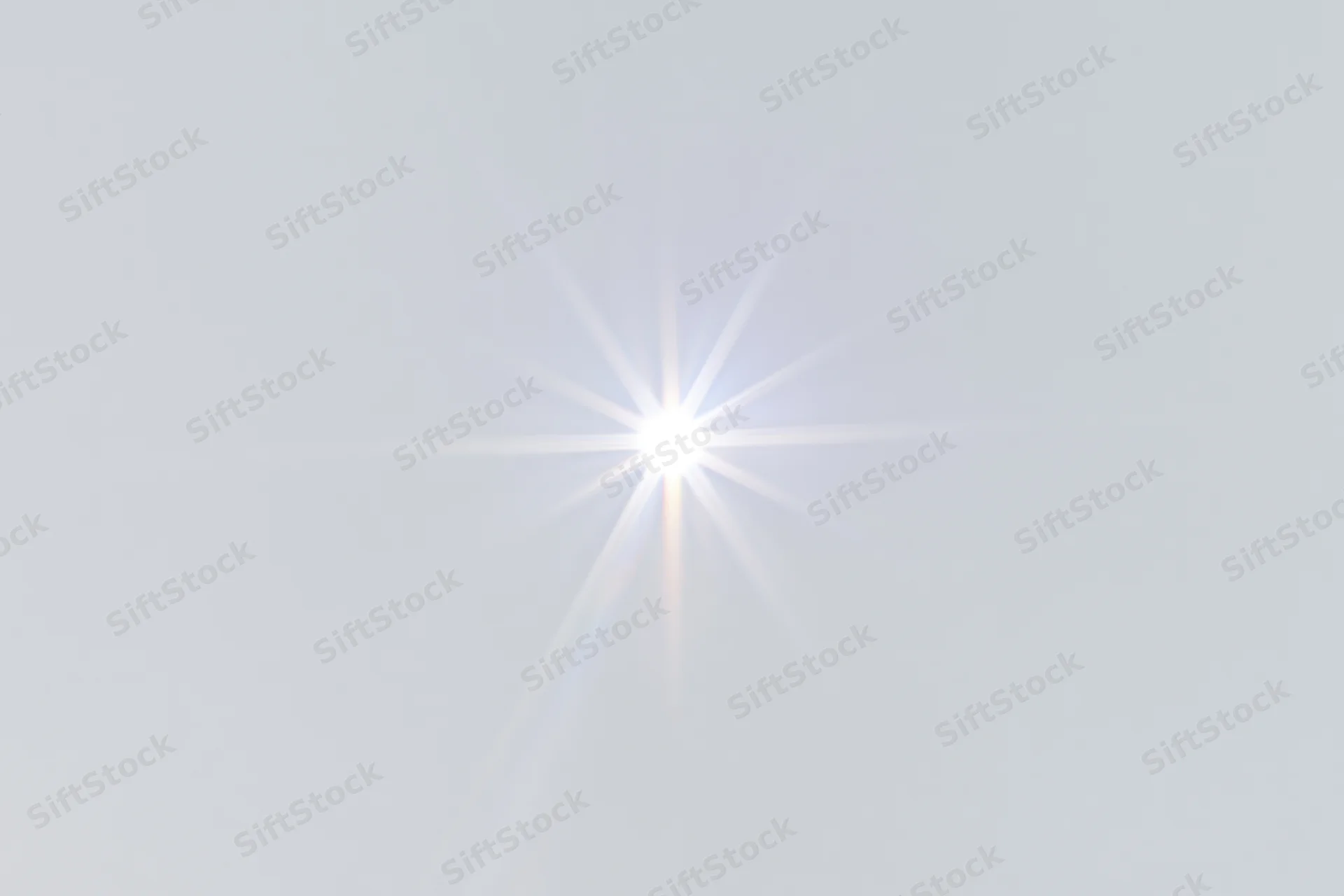 Bright lens flare starburst centered on a pure white background