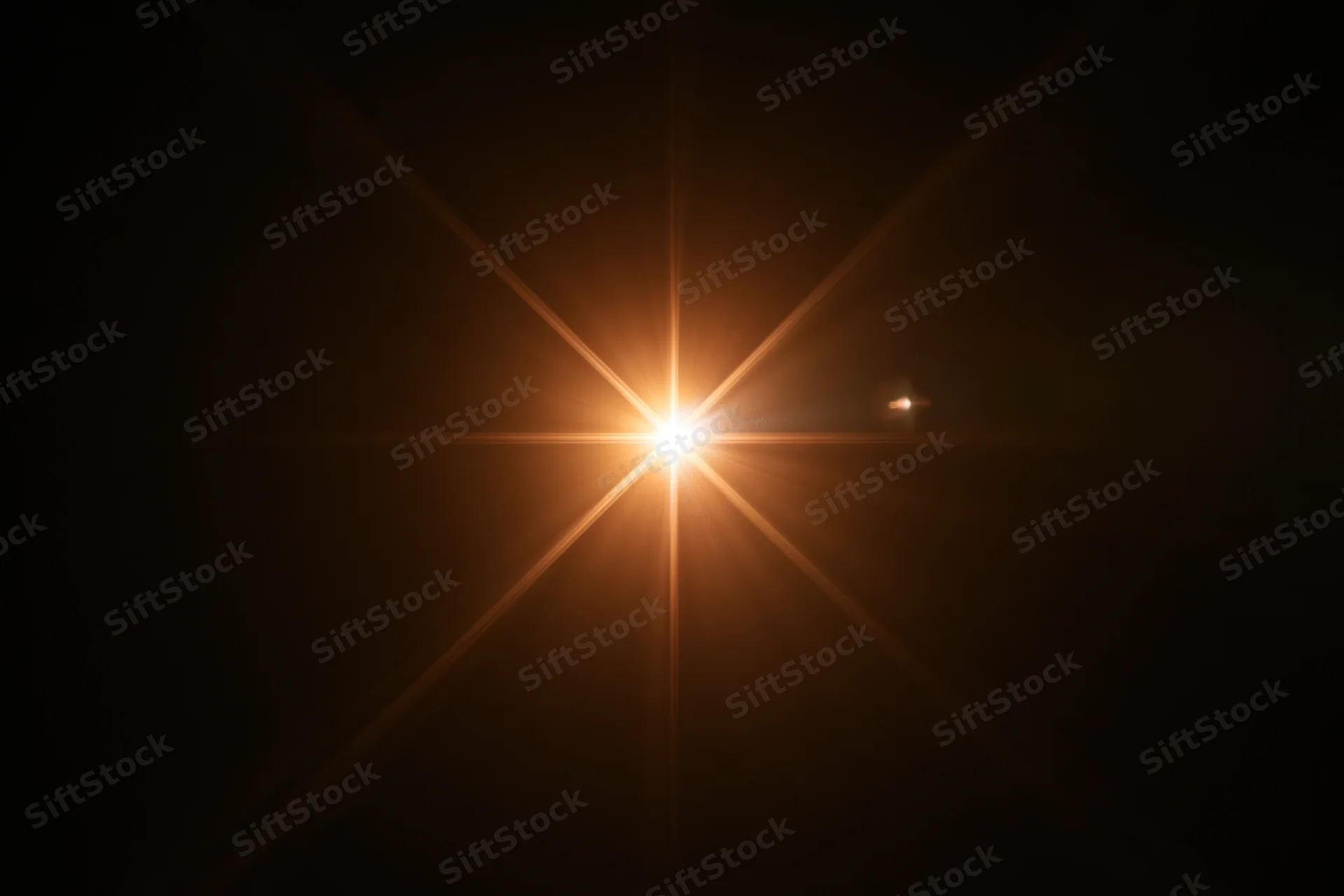 Bright point of light creating starburst flare against dark background