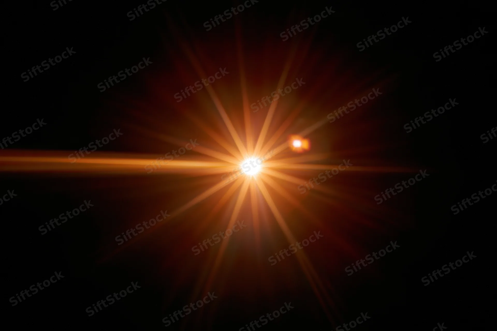 Bright point of light bursting with starburst flare against black background