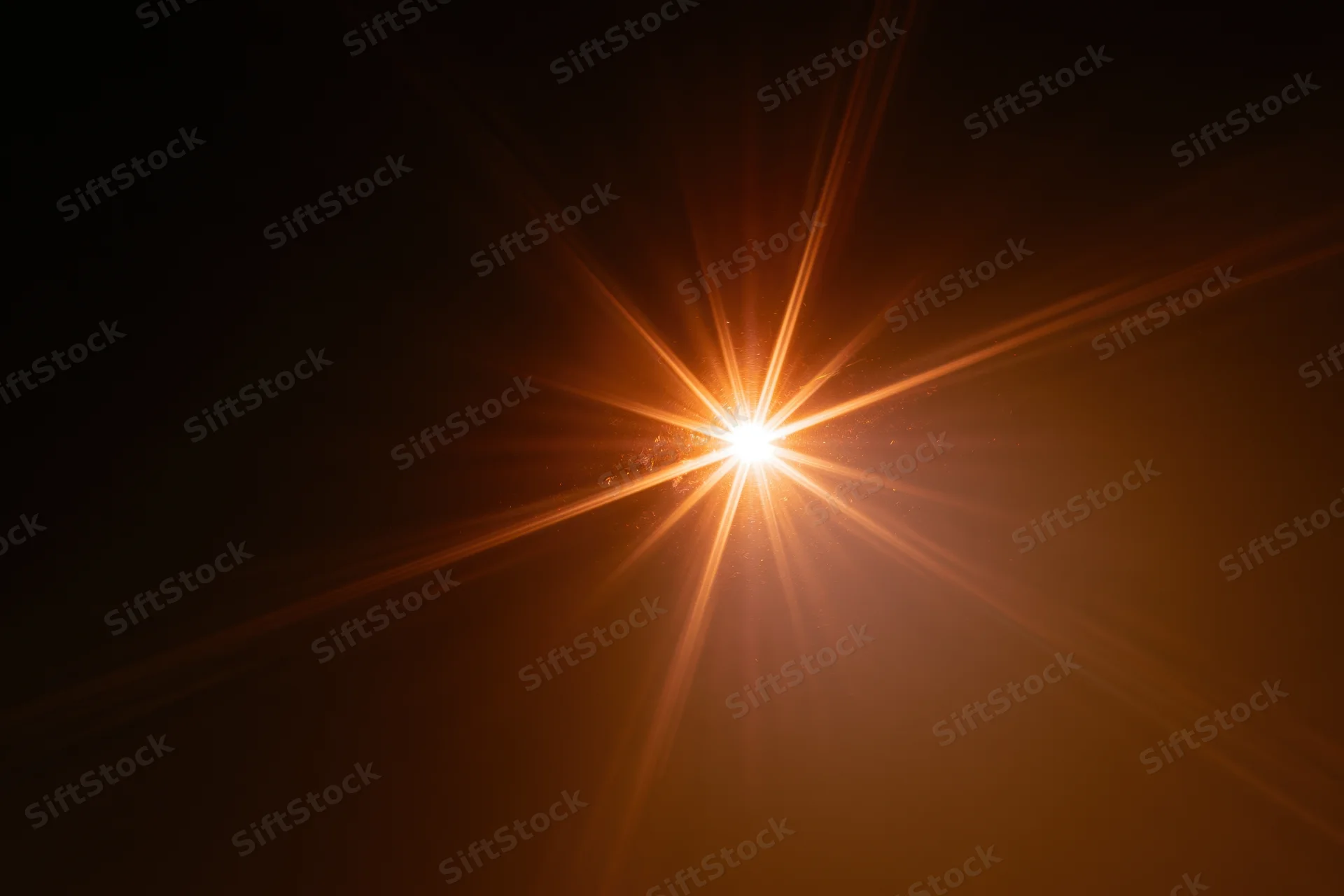 Intense light source bursting from center against dark background with radiant beams and warm glow