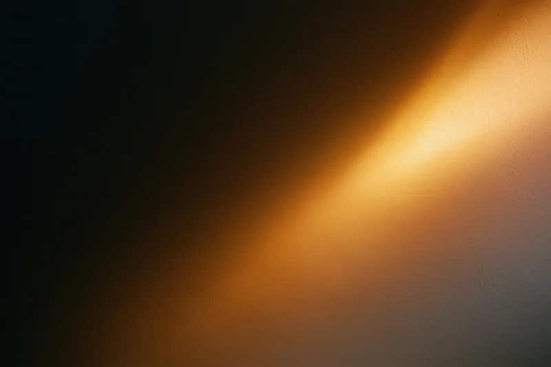 Warm amber light casting a soft diagonal glow across a textured wall interior