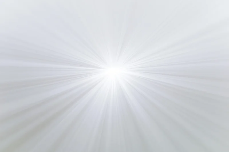 Soft radial burst of light rays emanating from a bright center against a white background