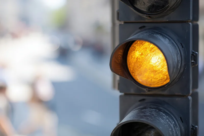 Vertical traffic light showing amber signal on city street