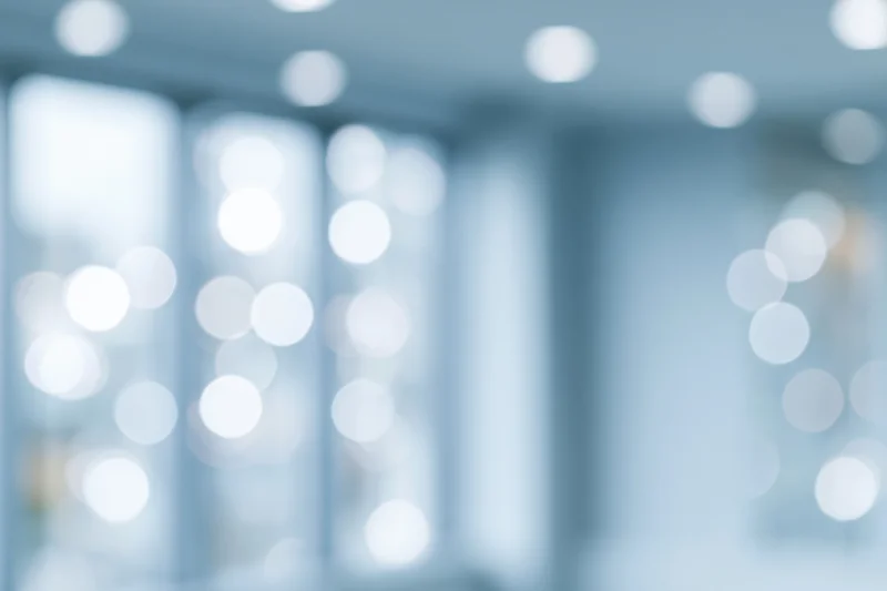 Blurred interior space with soft circular bokeh lights from ceiling fixtures and windows