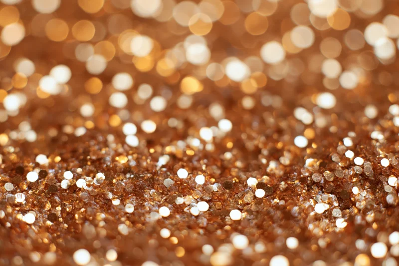 Densely packed glitter creating a sparkling bokeh effect with warm golden and brown tones