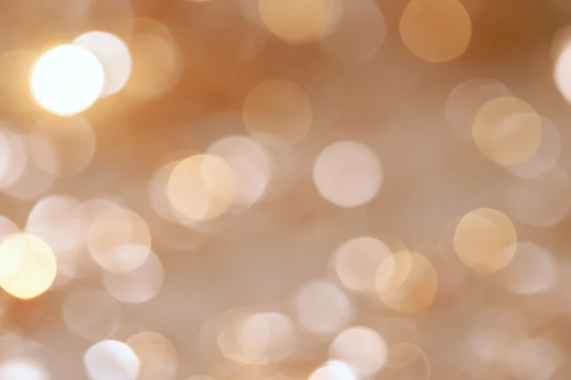 Soft out-of-focus golden light orbs forming a warm abstract background with copyspace