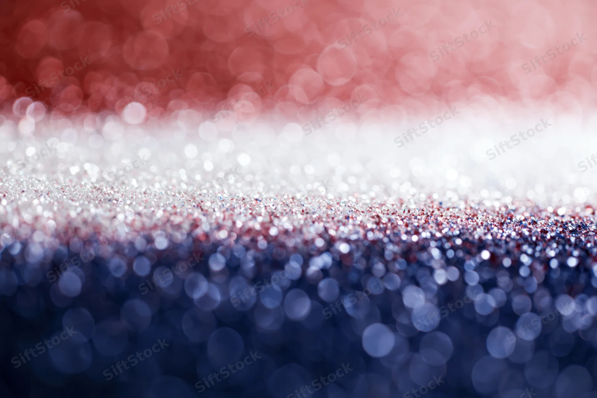 Abstract bokeh background with scattered light circles fading in red white and blue gradient