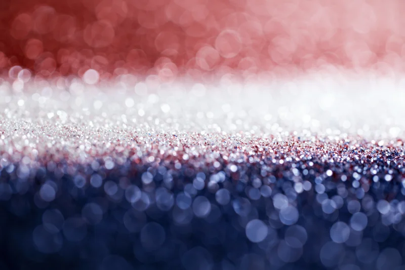Abstract bokeh background with scattered light circles fading in red white and blue gradient