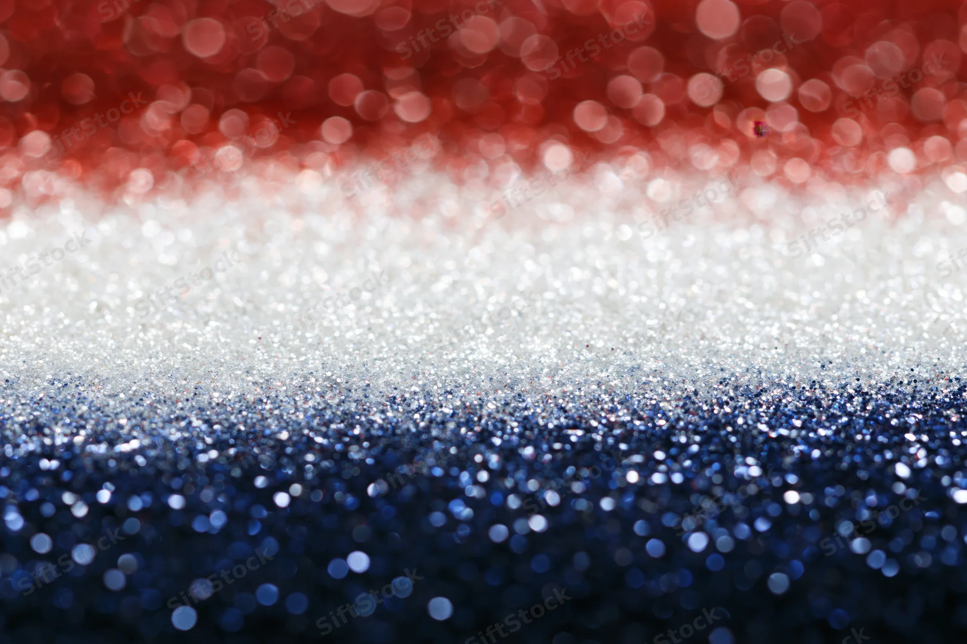 Abstract bokeh background with scattered light circles fading in red white and blue glitter texture