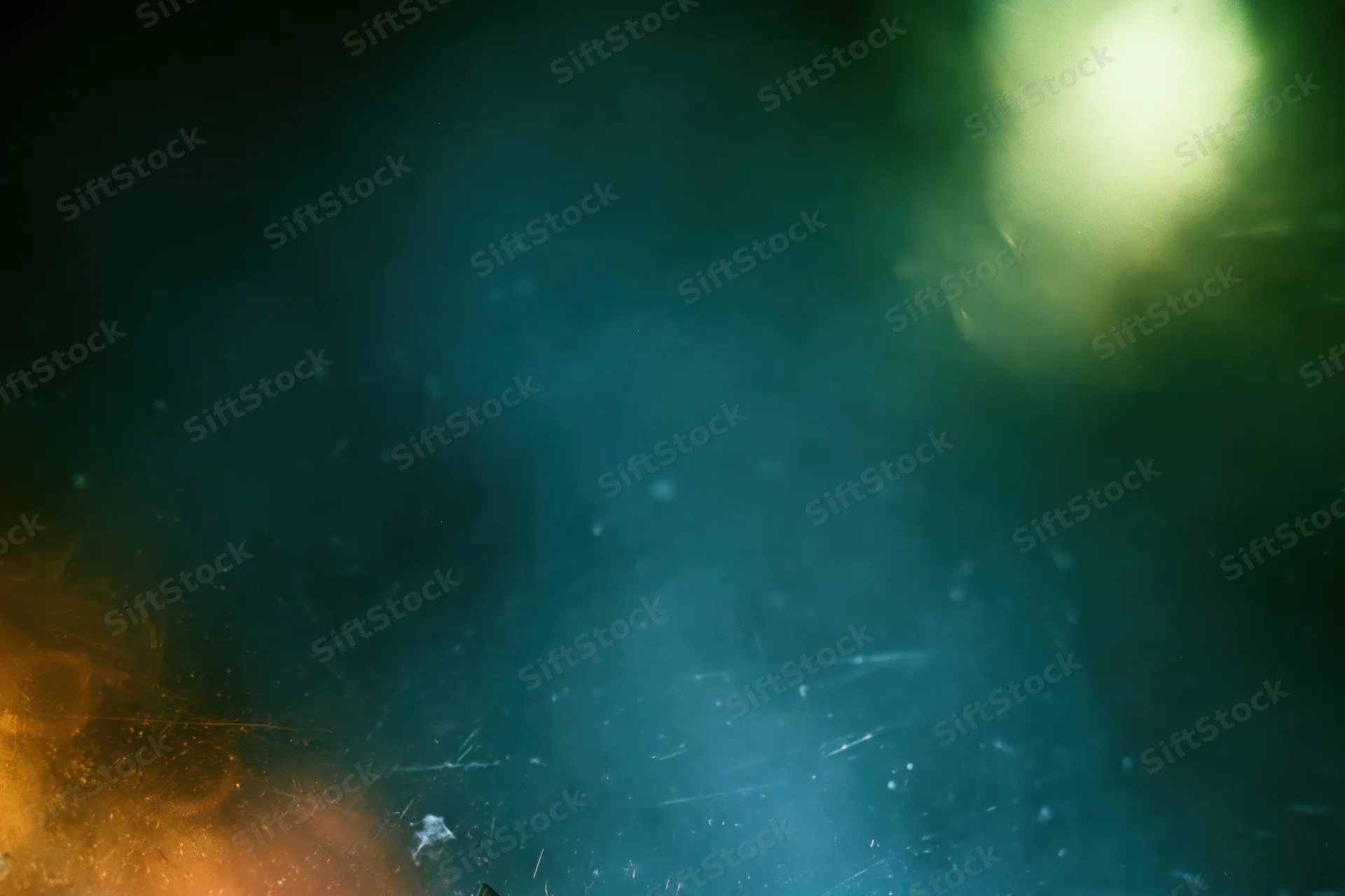 Abstract close-up of a dusty scratched glass surface with soft light and haze