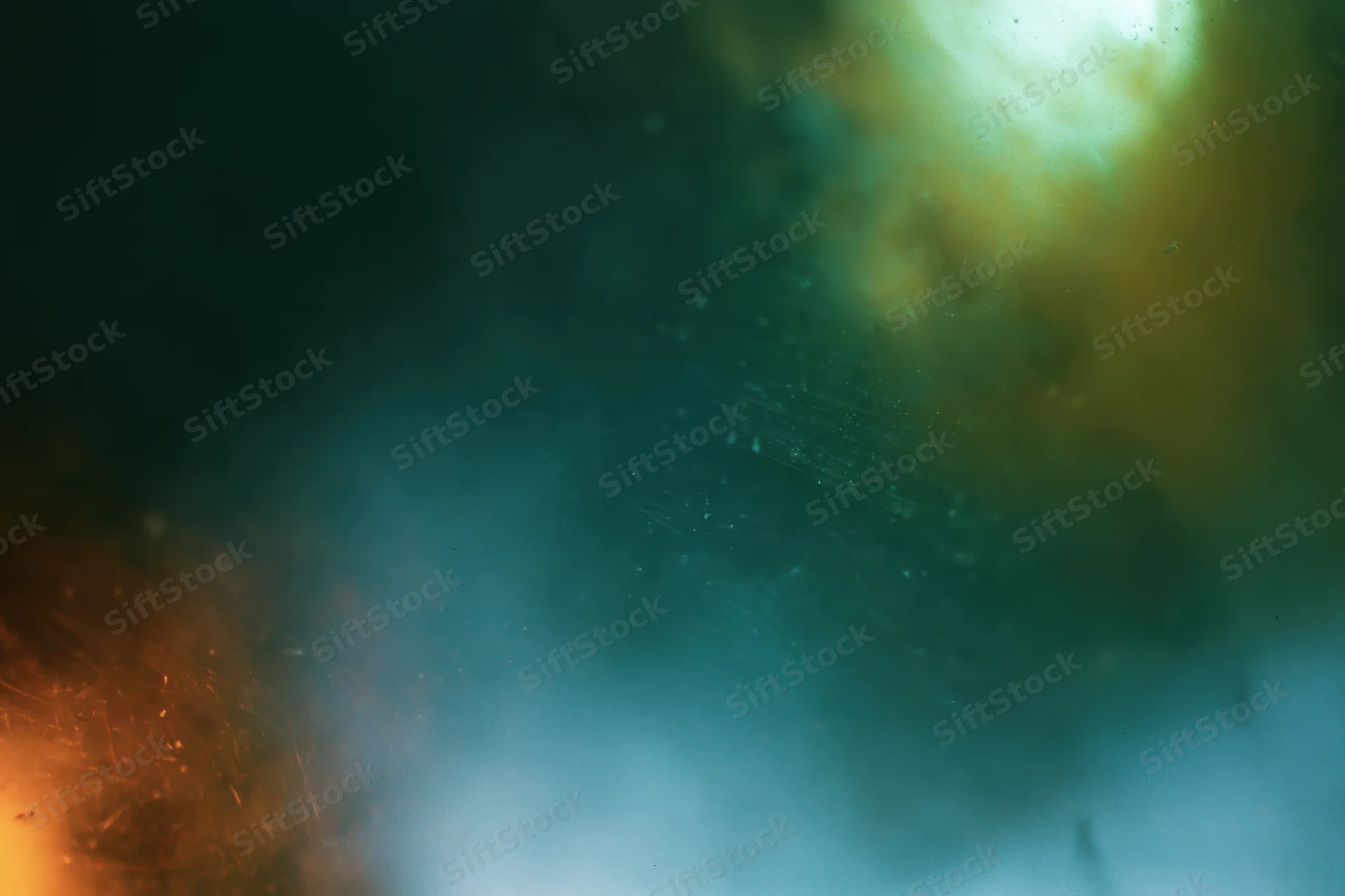 Abstract close-up of a dusty scratched glass surface with soft light and blurred particles