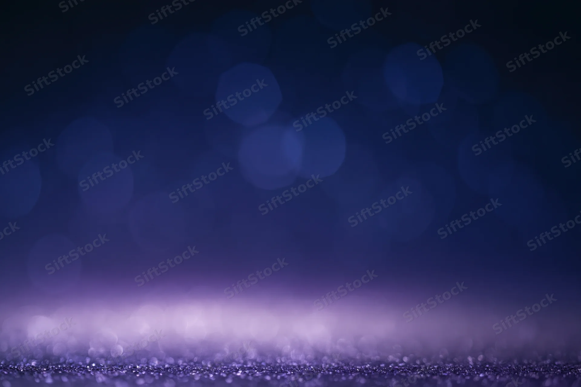 Dark studio backdrop with soft out-of-focus bokeh and glittery surface