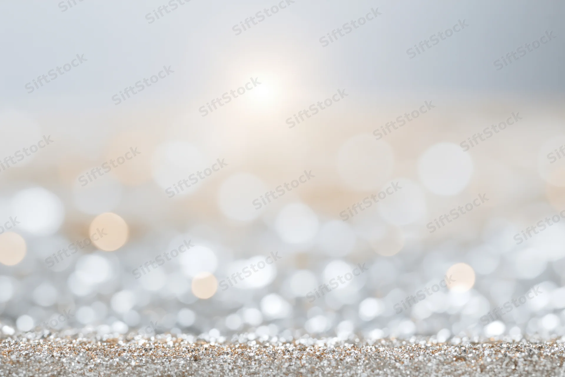 Abstract defocused background of scattered silver and warm gold tones