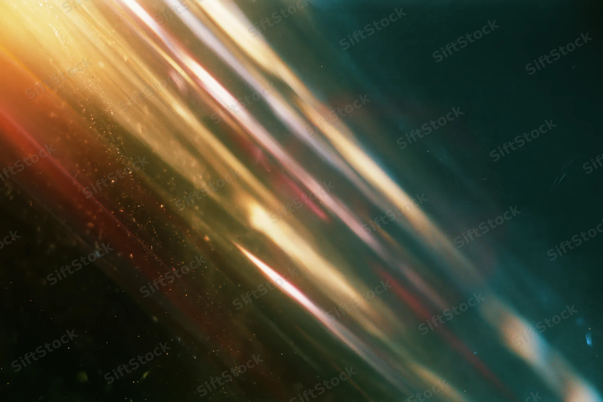 Diagonal light leak streaks across dark dusty surface with warm golden glow and speckled particles