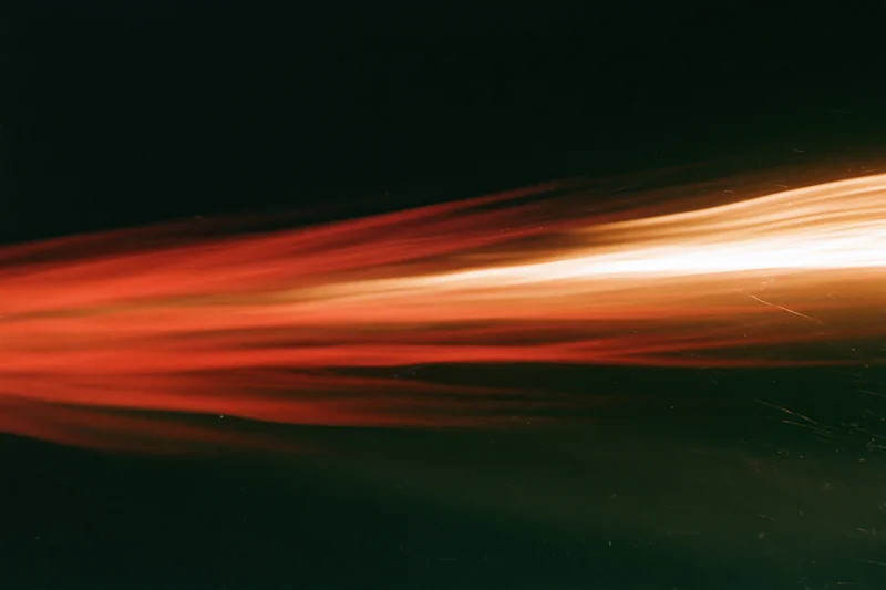 Horizontal light streaks blurring across dark background from long-exposure motion