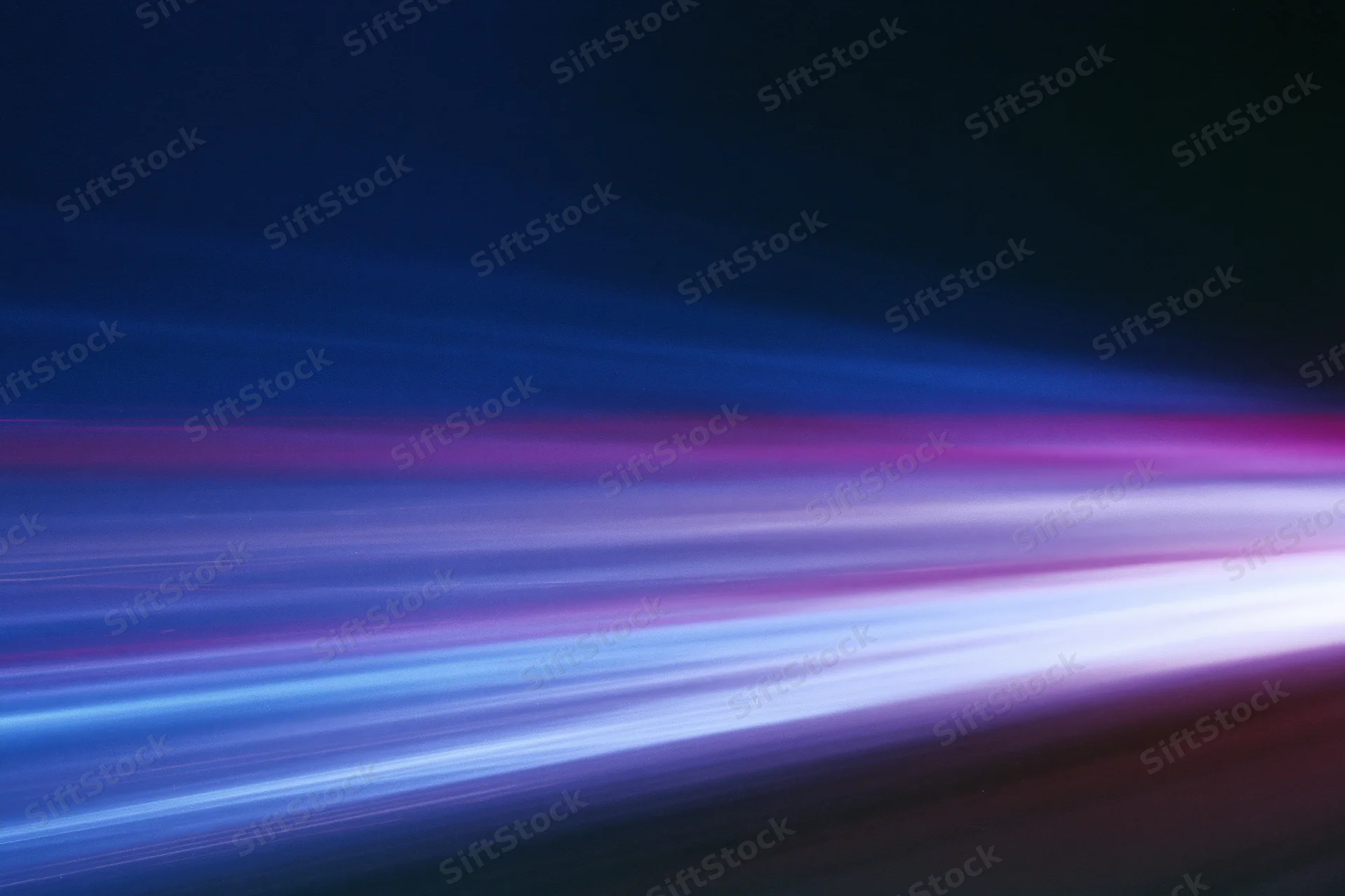 Horizontal light streaks from moving vehicles captured in long-exposure blur at night