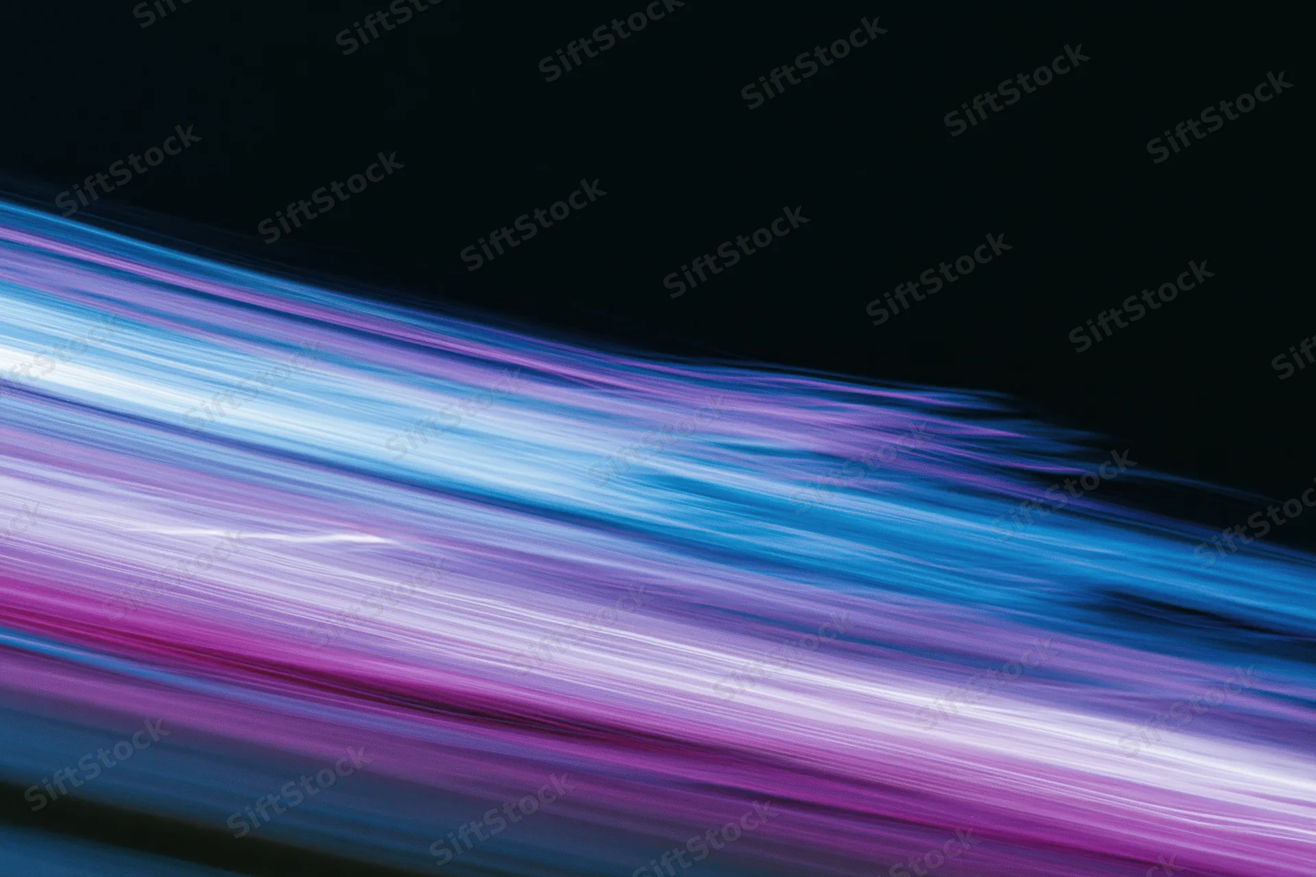 Abstract light streaks in motion blur against dark background