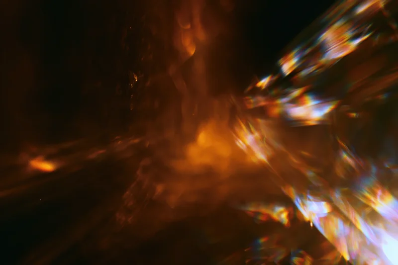 Abstract motion-blurred low-light scene with lens flare streaks and colorful light reflections