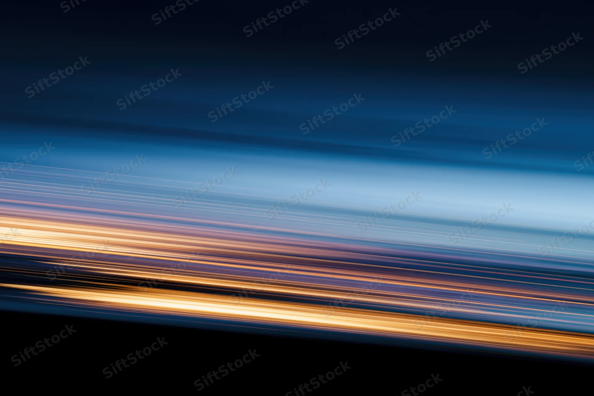 Horizontal light streaks from moving vehicles at night creating abstract motion blur background