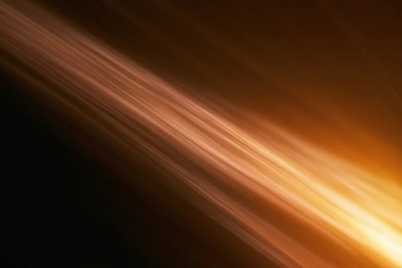 Warm light streaks moving diagonally across a dark background