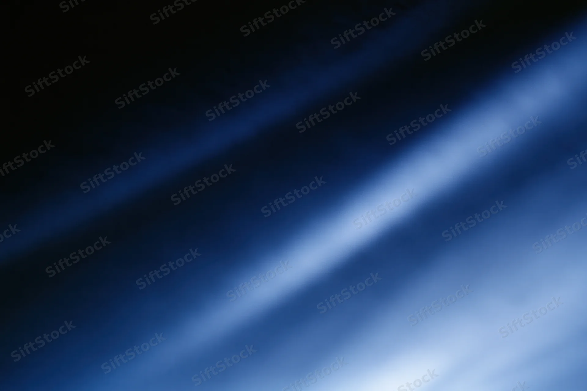 Diagonal light gradient fading from deep navy to bright white across abstract blurred background