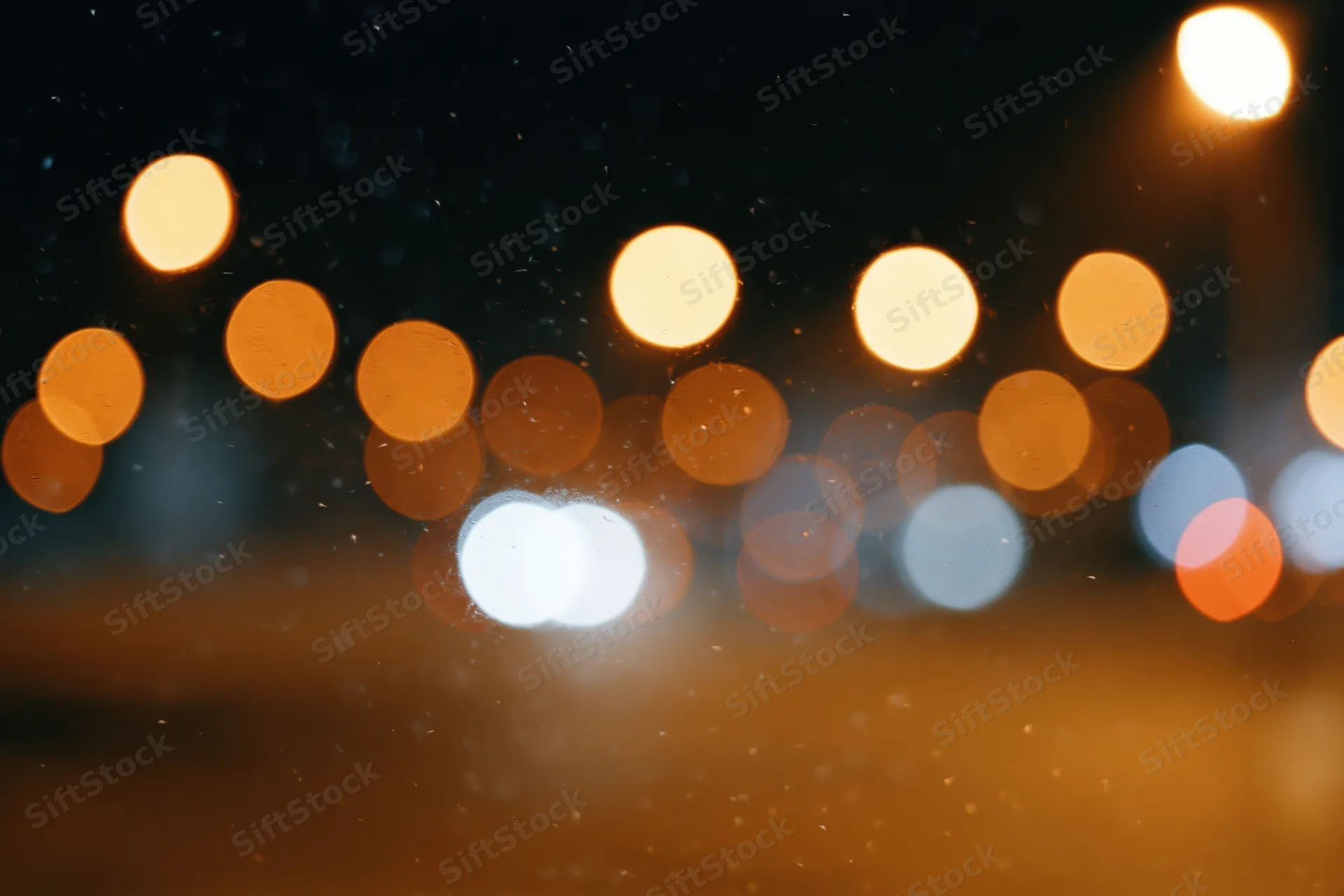 Blurred circular lights from city traffic at night with warm bokeh and atmospheric haze