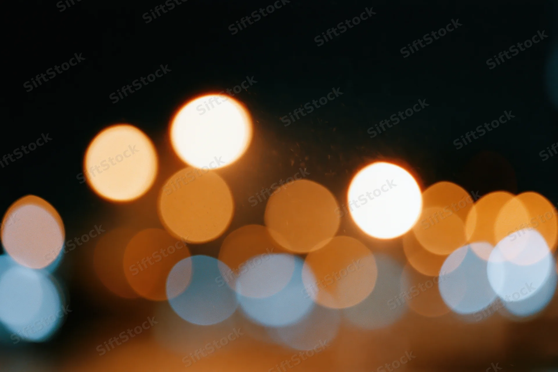 Warm and cool circular bokeh lights blurred in a night urban scene