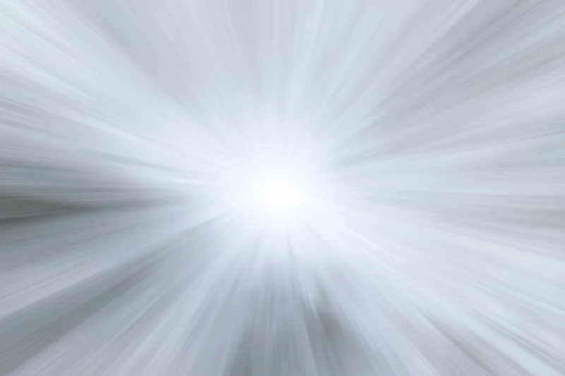 Bright white light radiating outward in radial motion blur pattern