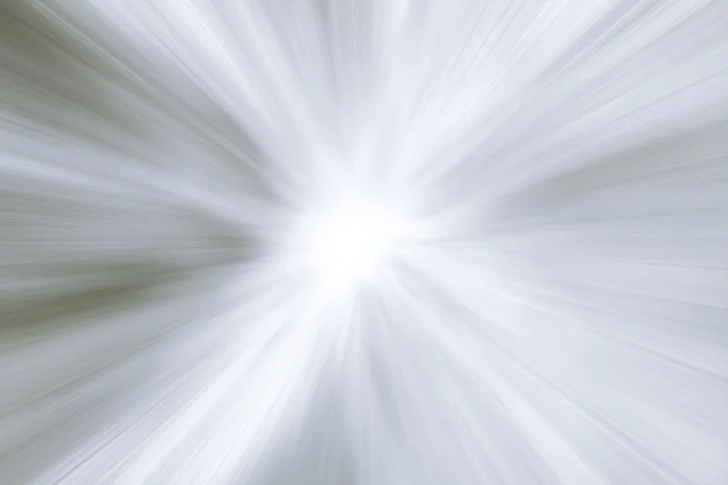 Bright white light radiating outward in radial motion blur pattern