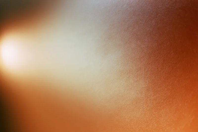 Soft glowing light bloom in warm orange gradient background