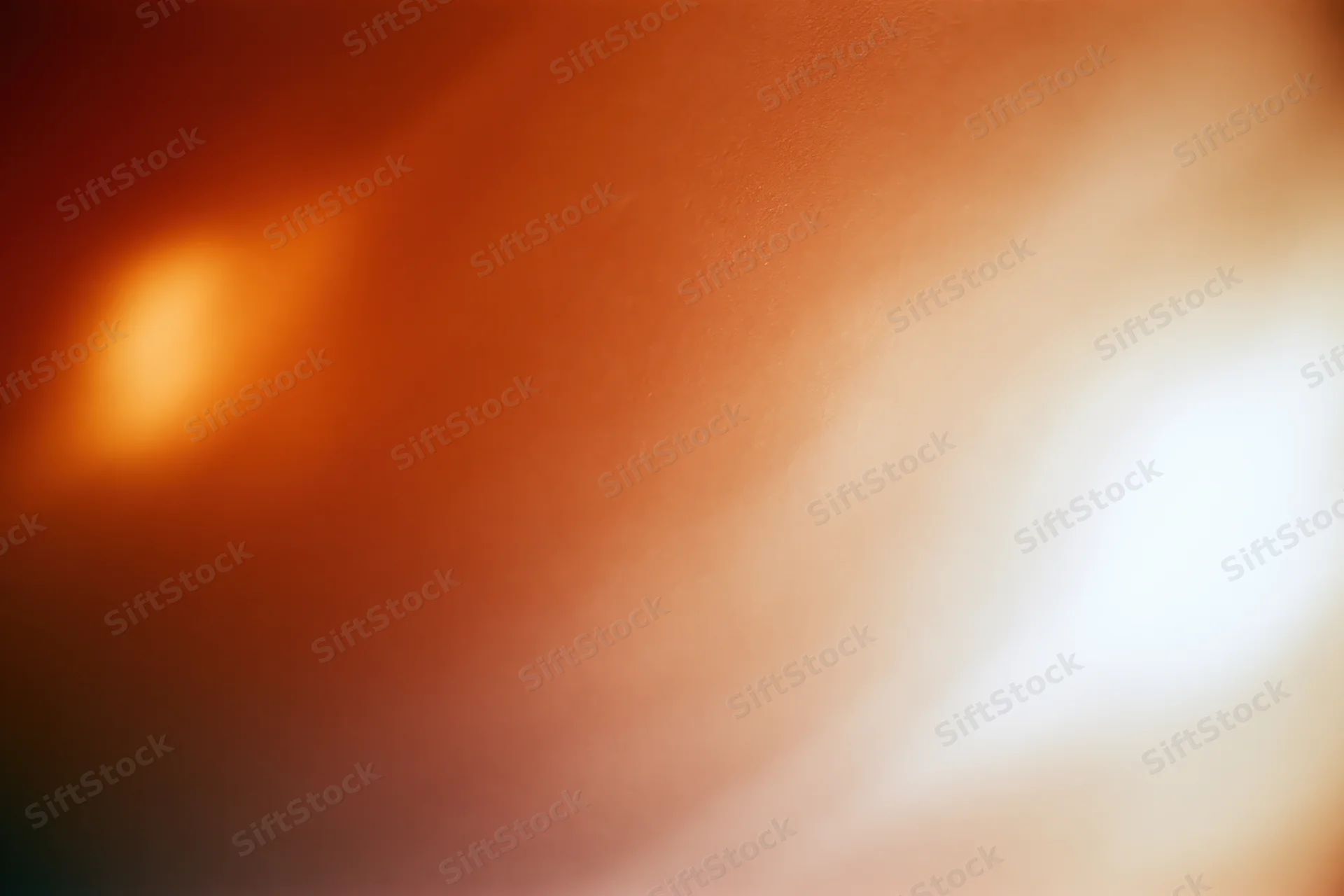 Soft glowing light bloom in warm orange and white tones filling the frame as abstract background