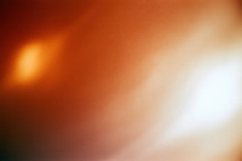 Soft glowing light bloom in warm orange and white tones filling the frame as abstract background