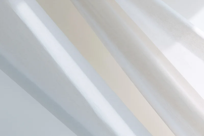 Diagonal white and light grey streaks forming a soft abstract pattern across a smooth surface