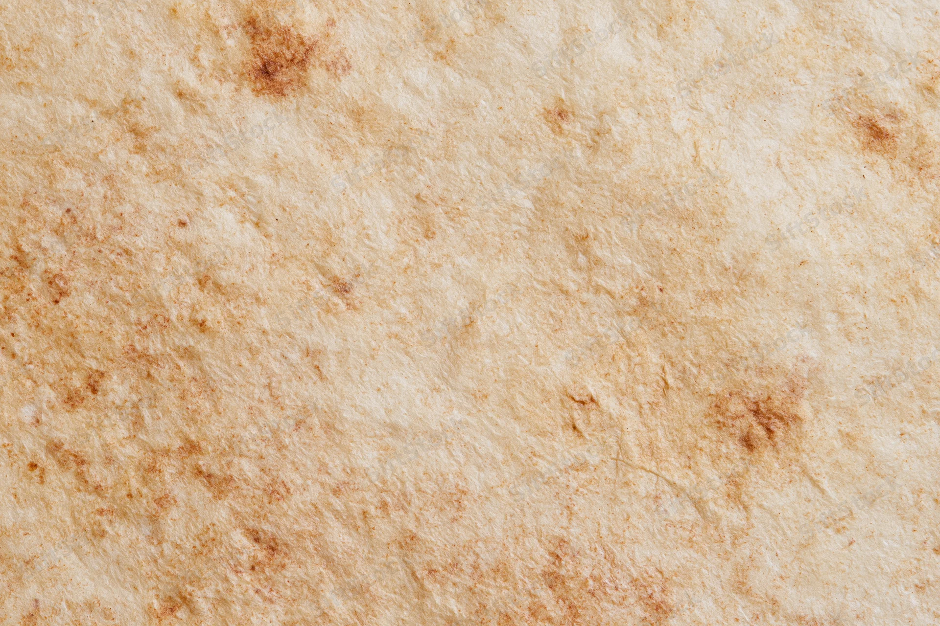Aged parchment paper surface filling the frame with natural texture and stains