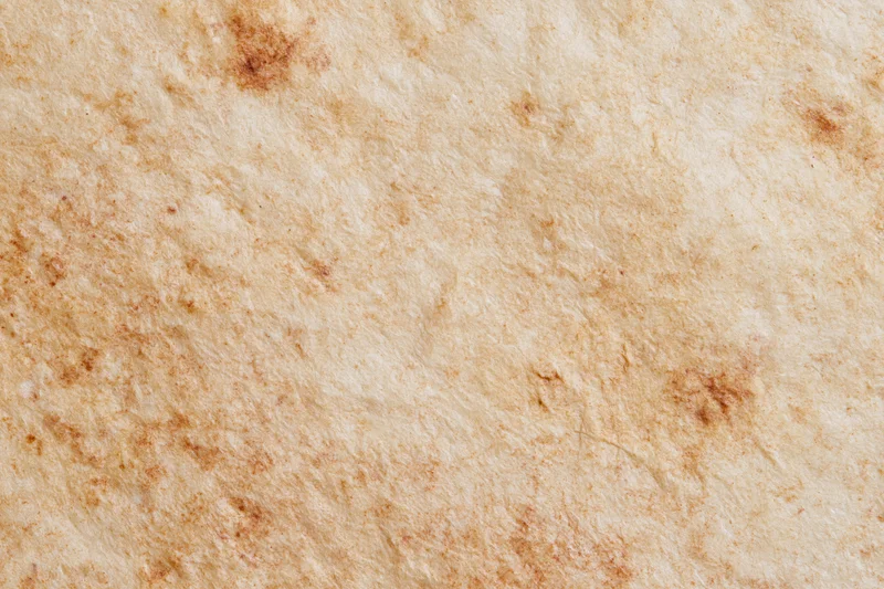 Aged parchment paper surface filling the frame with natural texture and stains