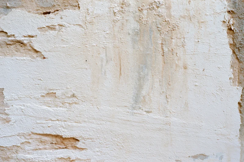 Aged plaster wall surface with peeling paint and cracks filling the frame