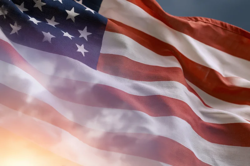 American flag rippling in wind filling the frame with stars and stripes against sky