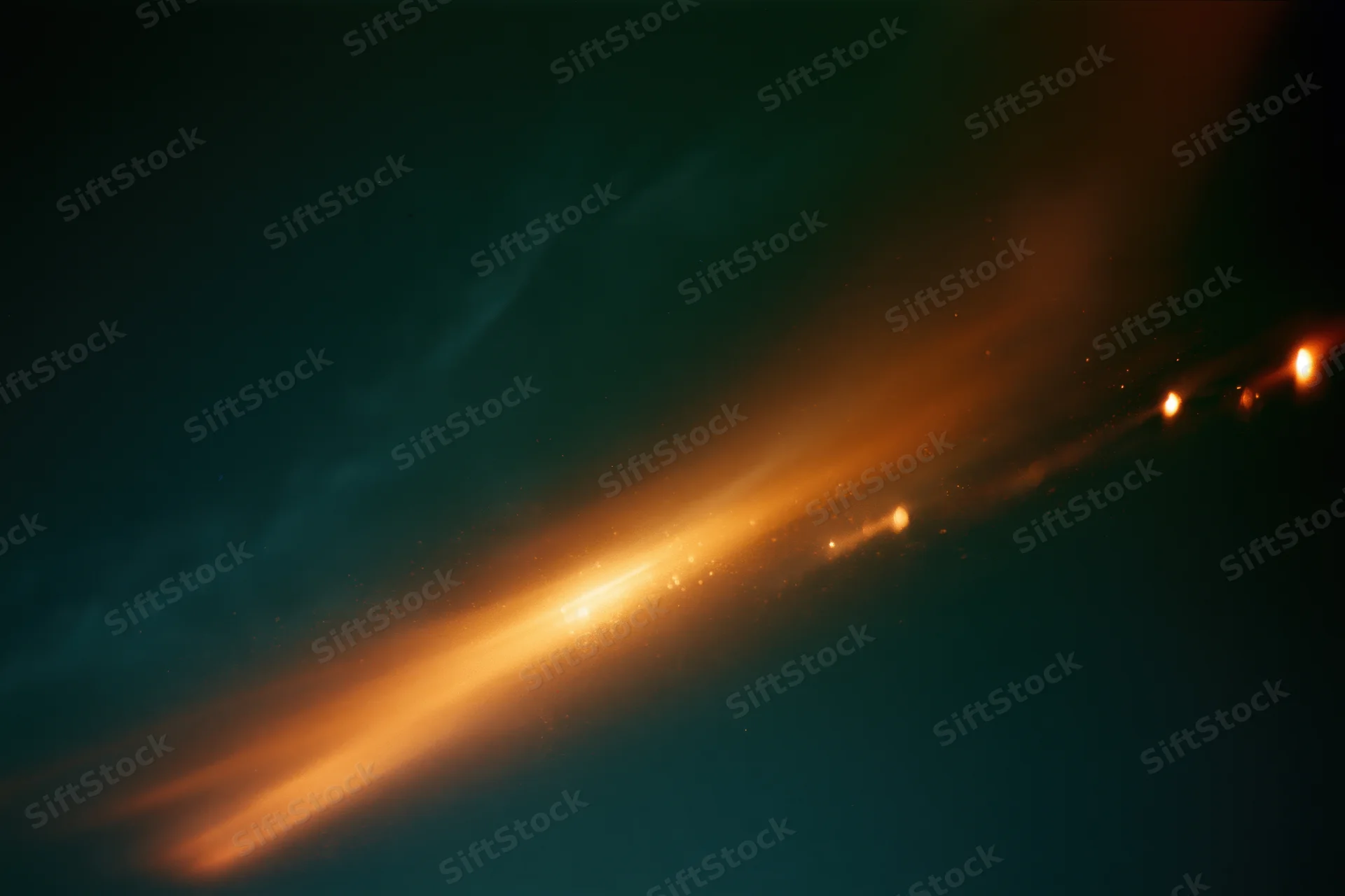 Warm light streaks and flares on dark abstract background from analog film exposure