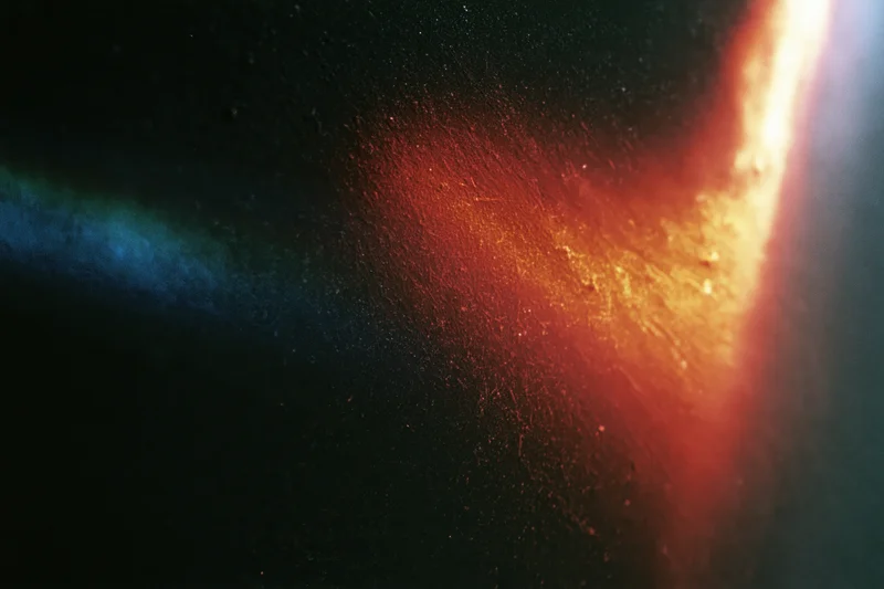 Diagonal light leak overlay on black background with red and blue gradients