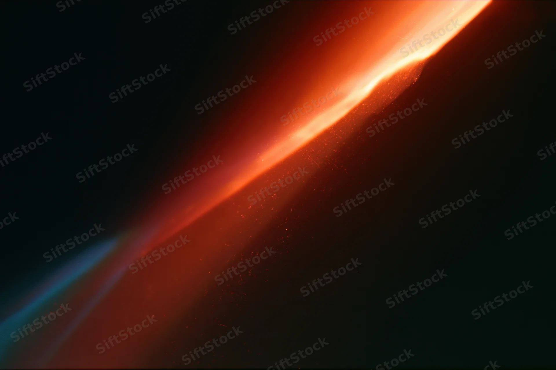 Diagonal analog film light leak overlay on black background with red and orange glow