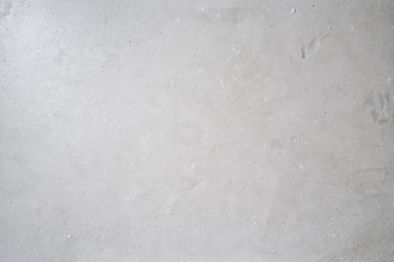 Bare concrete wall surface filling the frame with even texture and neutral gray tone