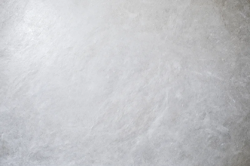 Bare concrete wall surface filling the frame with even texture and neutral gray tone