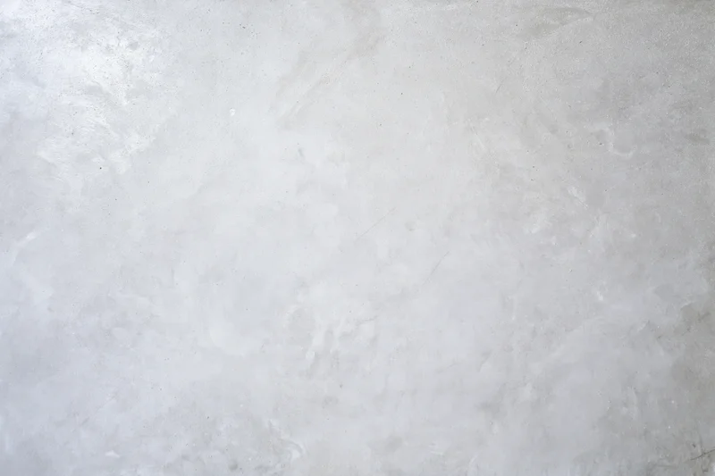 Bare concrete wall surface filling the frame with rough texture and neutral gray tone