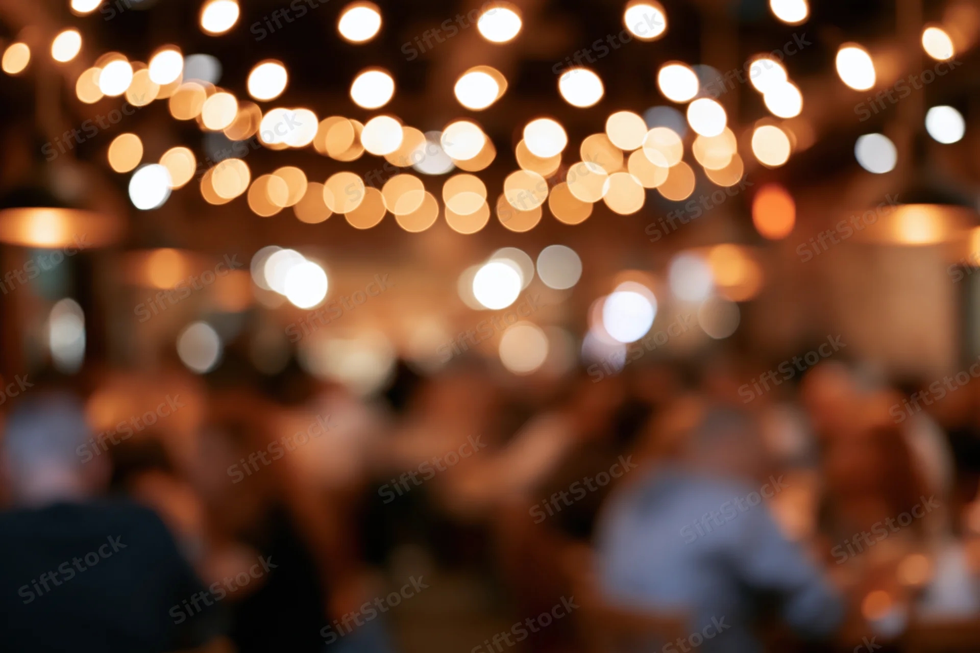 Blurred view of people dining in a warmly lit restaurant at night