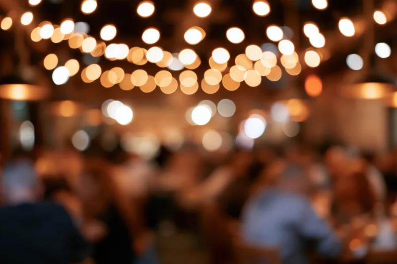 Blurred view of people dining in a warmly lit restaurant at night
