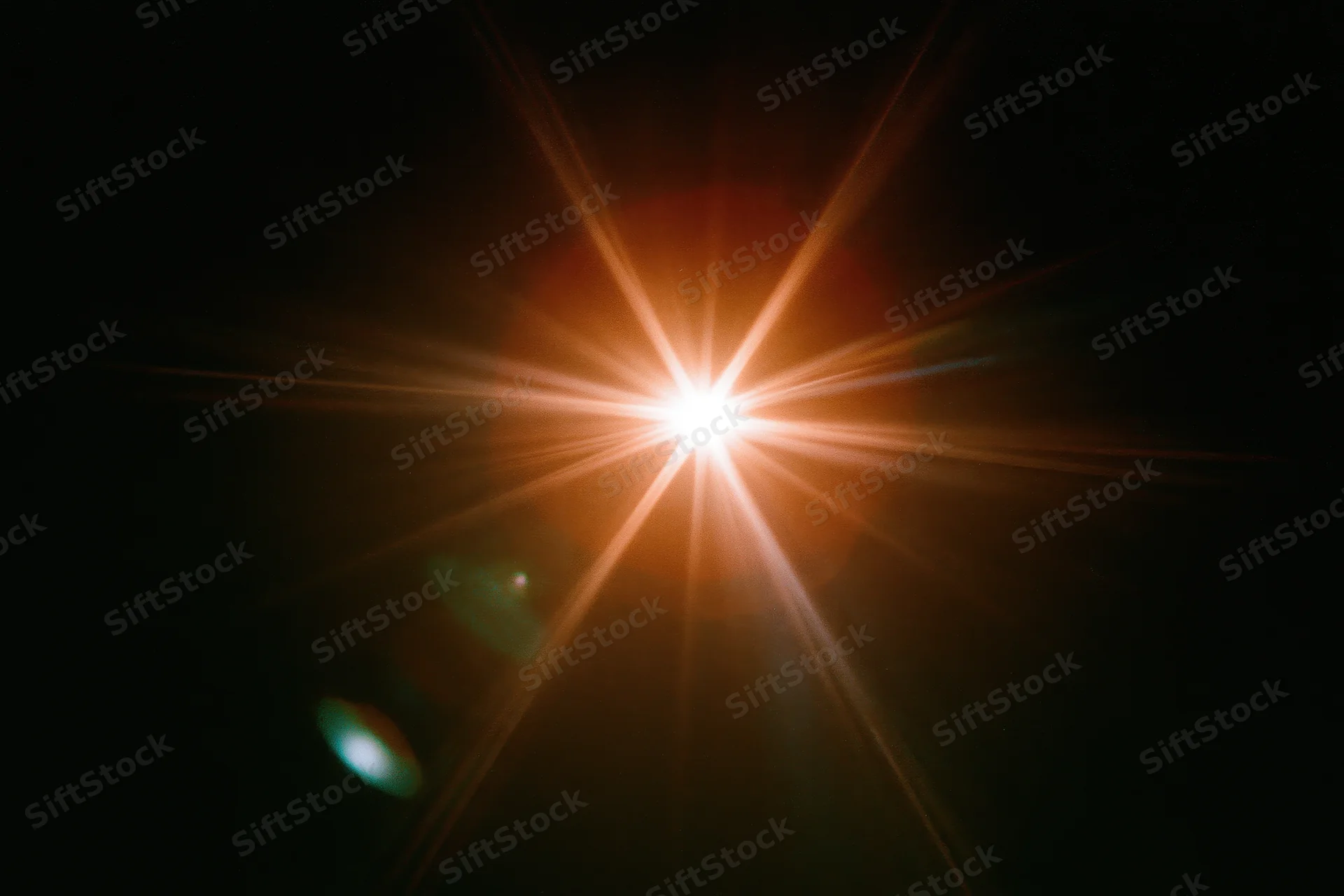 Bright point light source glowing with starburst flare against black background