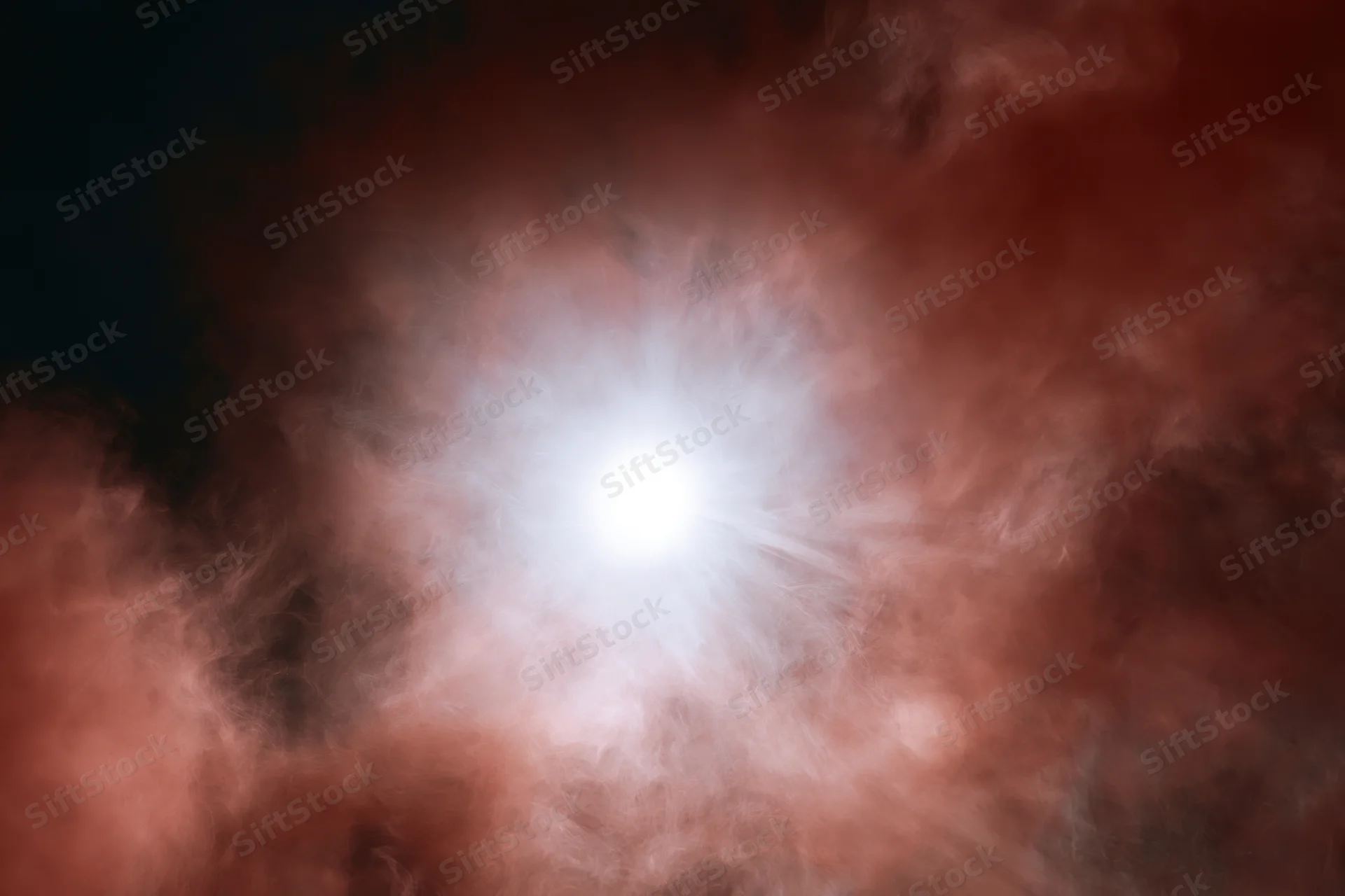 Bright white glowing orb at center surrounded by billowing red and pink cosmic clouds in space